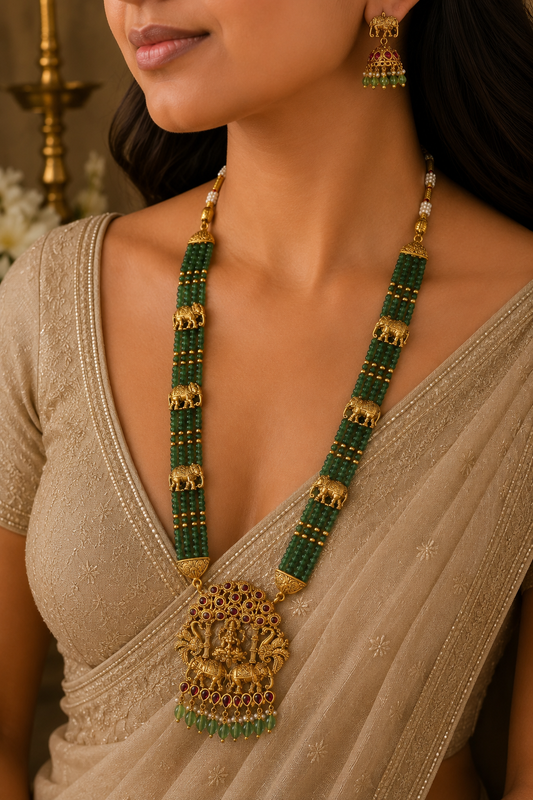 Belumiee Gaja Lakshmi Emerald Pearl Haram set featuring a long Indian imitation necklace with intricate design and pearl accents.