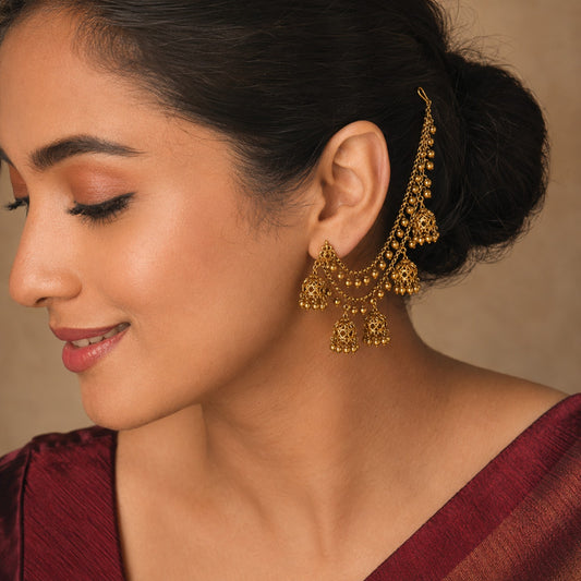 Model wearing an antique gold layered ghungroo jhumka ear chain by Belumiee