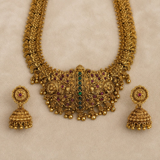 Antique gold peacock temple long haram necklace and jhumka set with ruby and green accents, intricate traditional jewelry by Belumiee