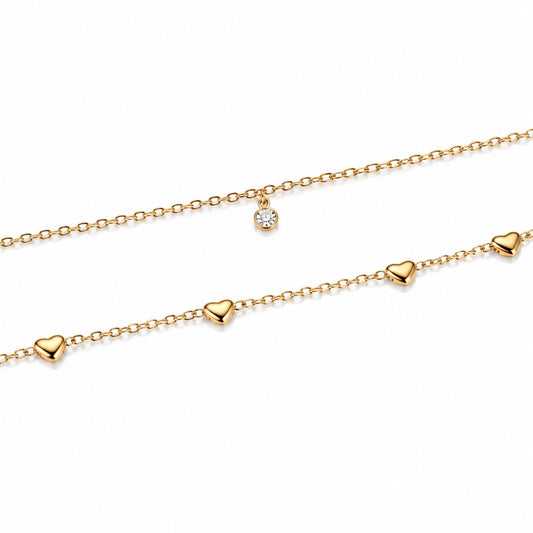 Close-up of polished heart stations and clear crystal-style accent on gold-tone hip chain