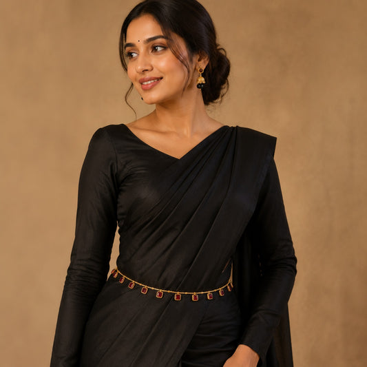 Model wearing ruby square stone gold-tone hip chain with black saree