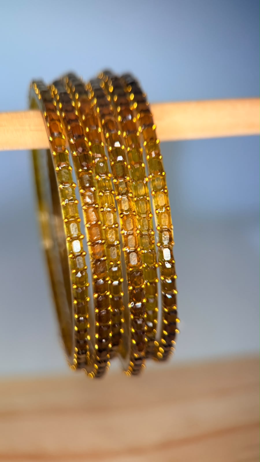 Belumiee Navrang Sparkle Glass Bangles Set featuring amber gold-colored bangles with shimmering glass finish.