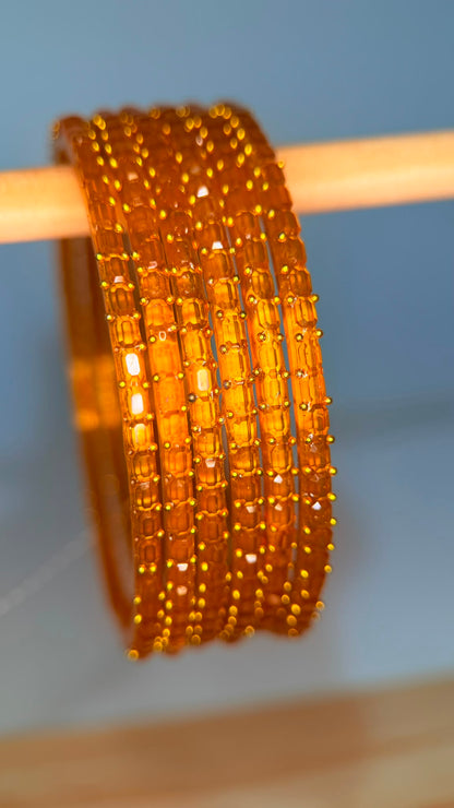 Amber orange Navrang Sparkle glass bangles set by Belumiee, featuring shimmering, decorative bangles for traditional or festive wear.