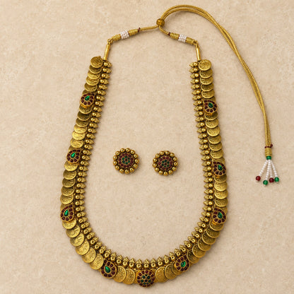 Antique gold coin Kasu Mala long Haram necklace and matching earrings set with ruby and green accents, traditional Indian jewelry.
