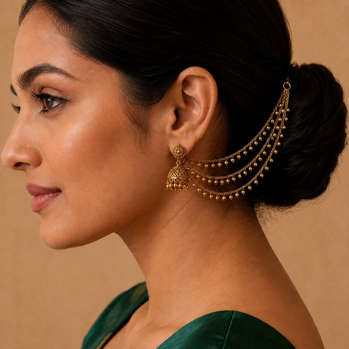 Model wearing one side of the antique gold triple-layer ghungroo ear chain pair by Belumiee