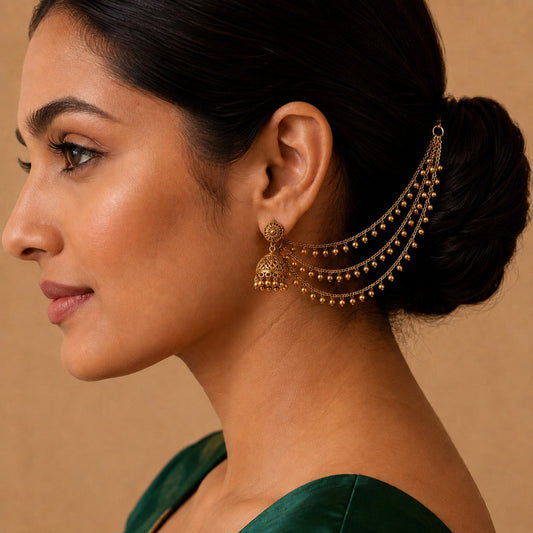 Model wearing one side of the antique gold triple-layer ghungroo ear chain pair by Belumiee
