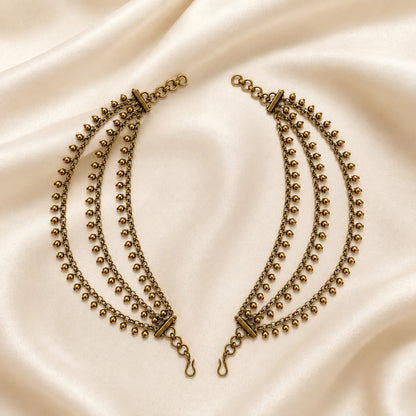Antique gold triple-layer gold bead fringe ear chain pair displayed on satin