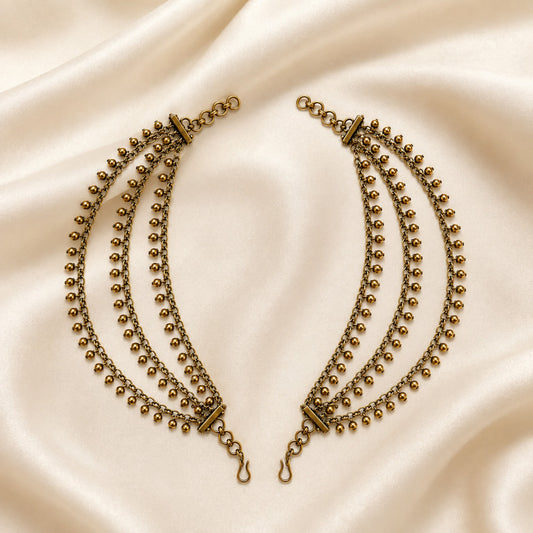 Antique gold triple-layer gold bead fringe ear chain pair displayed on satin