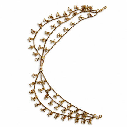 Detailed view of antique gold triple-layer pearl cluster ear chains