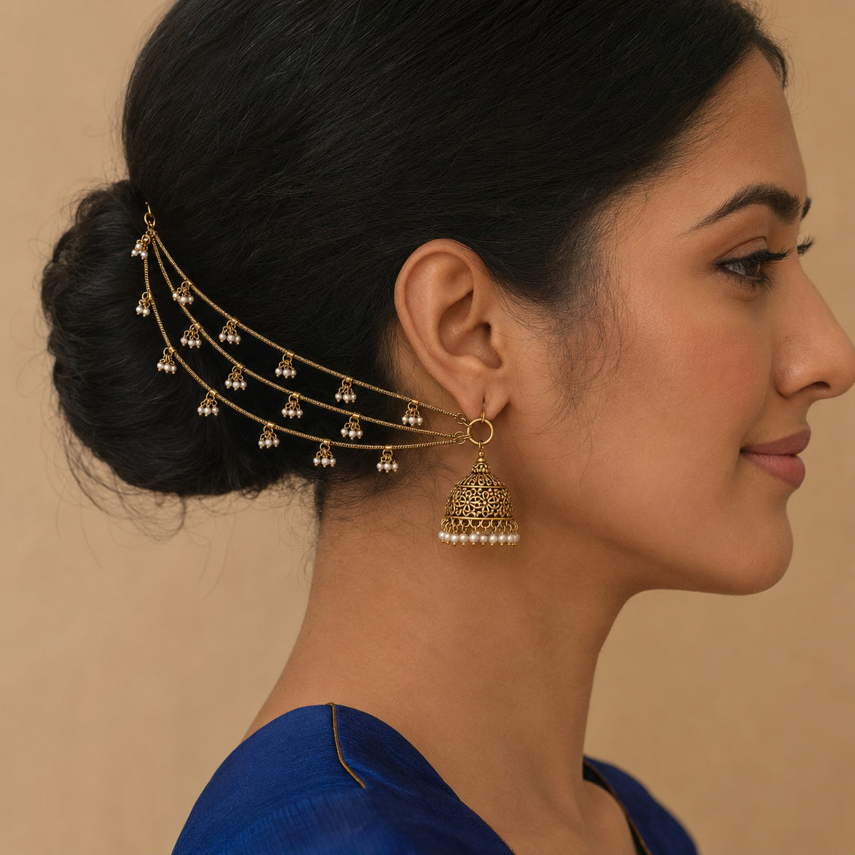 Model wearing one side of an antique gold triple-layer pearl cluster ear chain pair