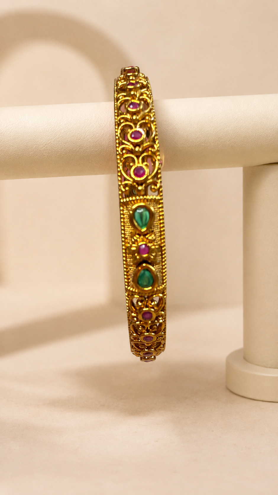 Antique ruby and emerald filigree bangle from Belumiee, showcasing intricate metalwork and vibrant gemstone details.
