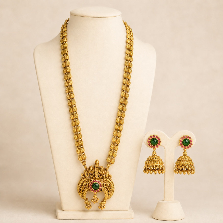 Antique gold temple pendant long necklace and jhumka earrings set with green ruby accents, traditional Indian jewelry by Belumiee.