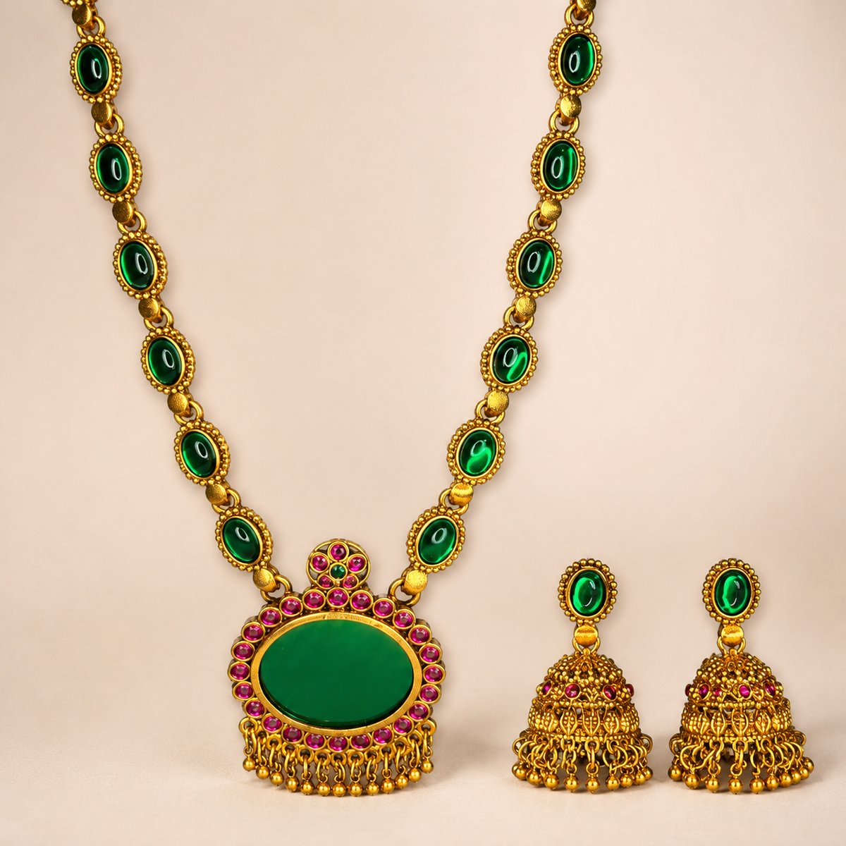 Close-up of Belumiee emerald and ruby long necklace and jhumka earrings set, showcasing intricate jewelry details and vibrant gemstones.