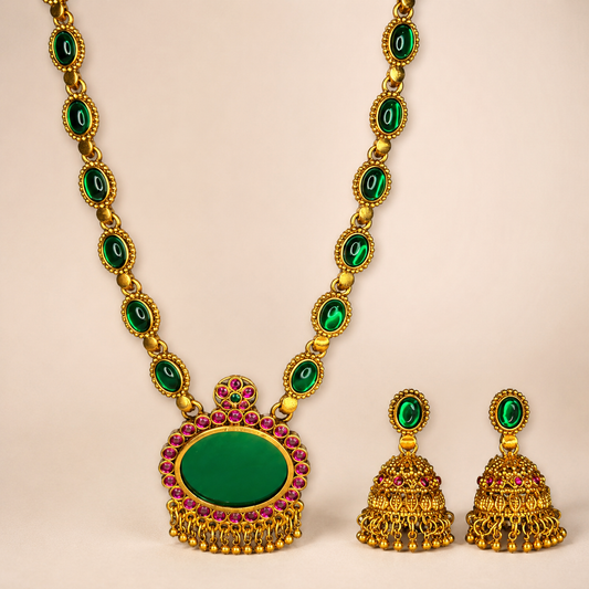 Close-up of Belumiee emerald and ruby long necklace and jhumka earrings set, showcasing intricate jewelry details and vibrant gemstones.