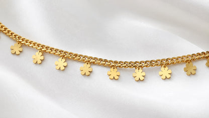 Close-up of polished flower charms on a gold-tone curb-chain hip chain