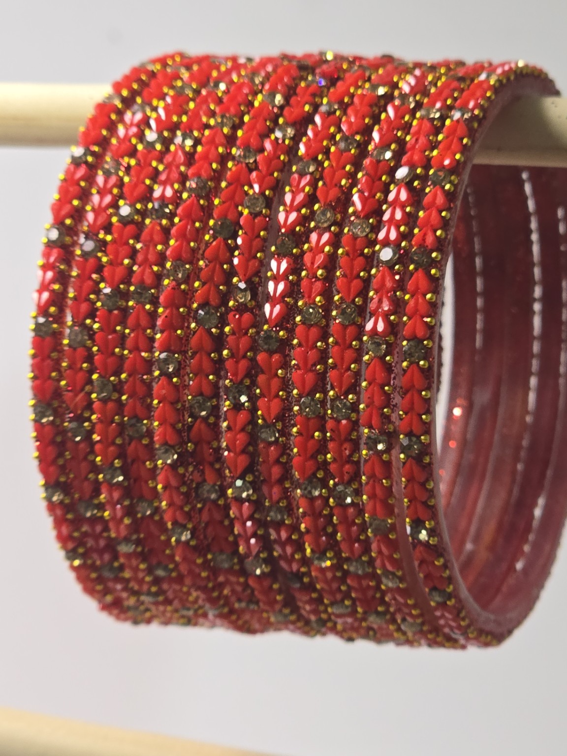 Tomato red Protima glass bangles with raised leaf and stone detailing