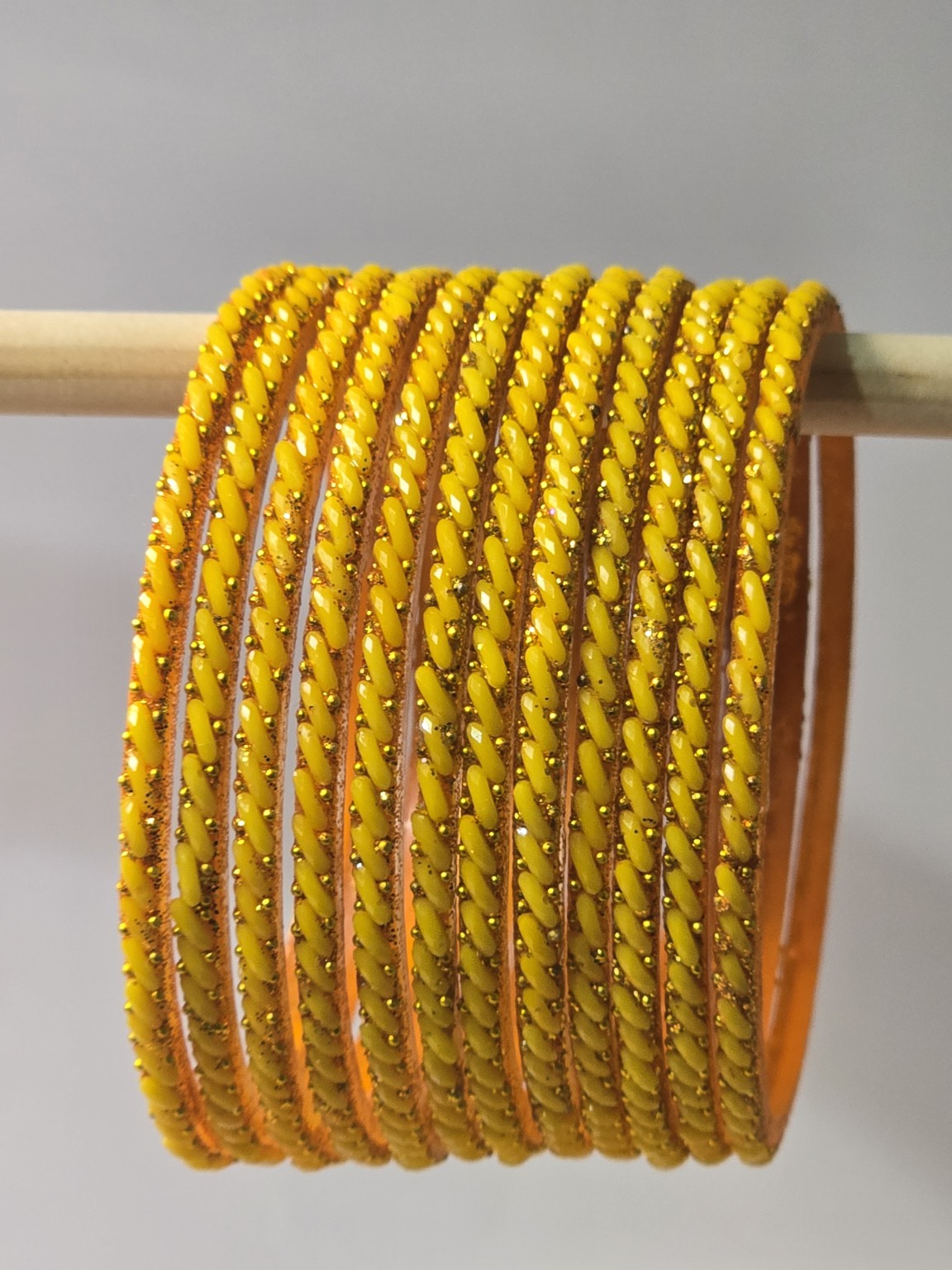Mango yellow Ratna twisted glass bangles with gold-dot detailing