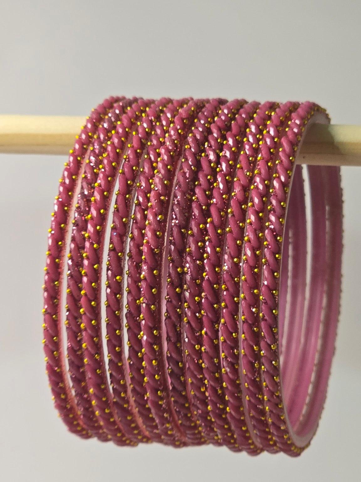 Onion dusty-pink Ratna twisted glass bangles with gold-dot detailing