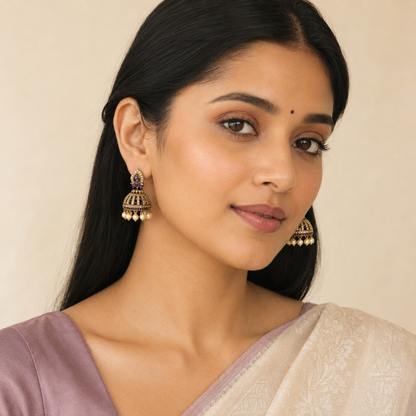 Model wearing Amethyst Purple crystal cage jhumka earrings with pearl-style drops