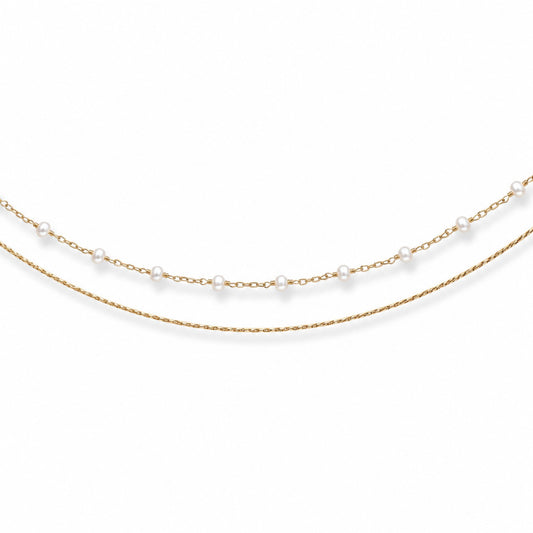 Close-up of double-layer gold-tone hip chain with small evenly spaced white pearls