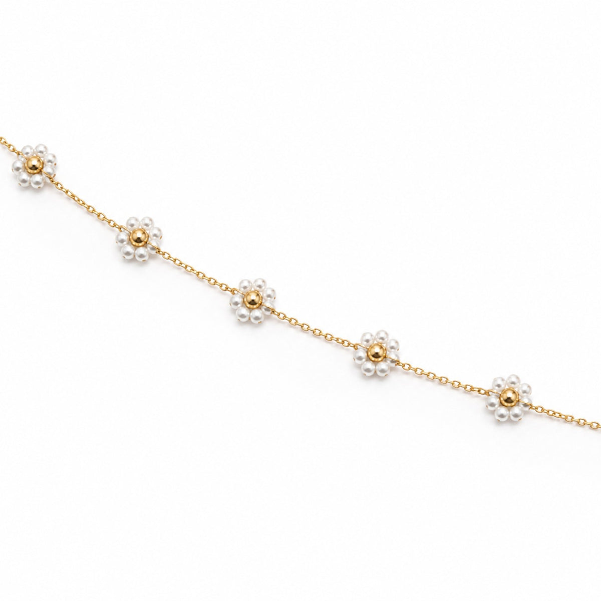 Close-up of white pearl flower motifs with polished gold-tone bead centres