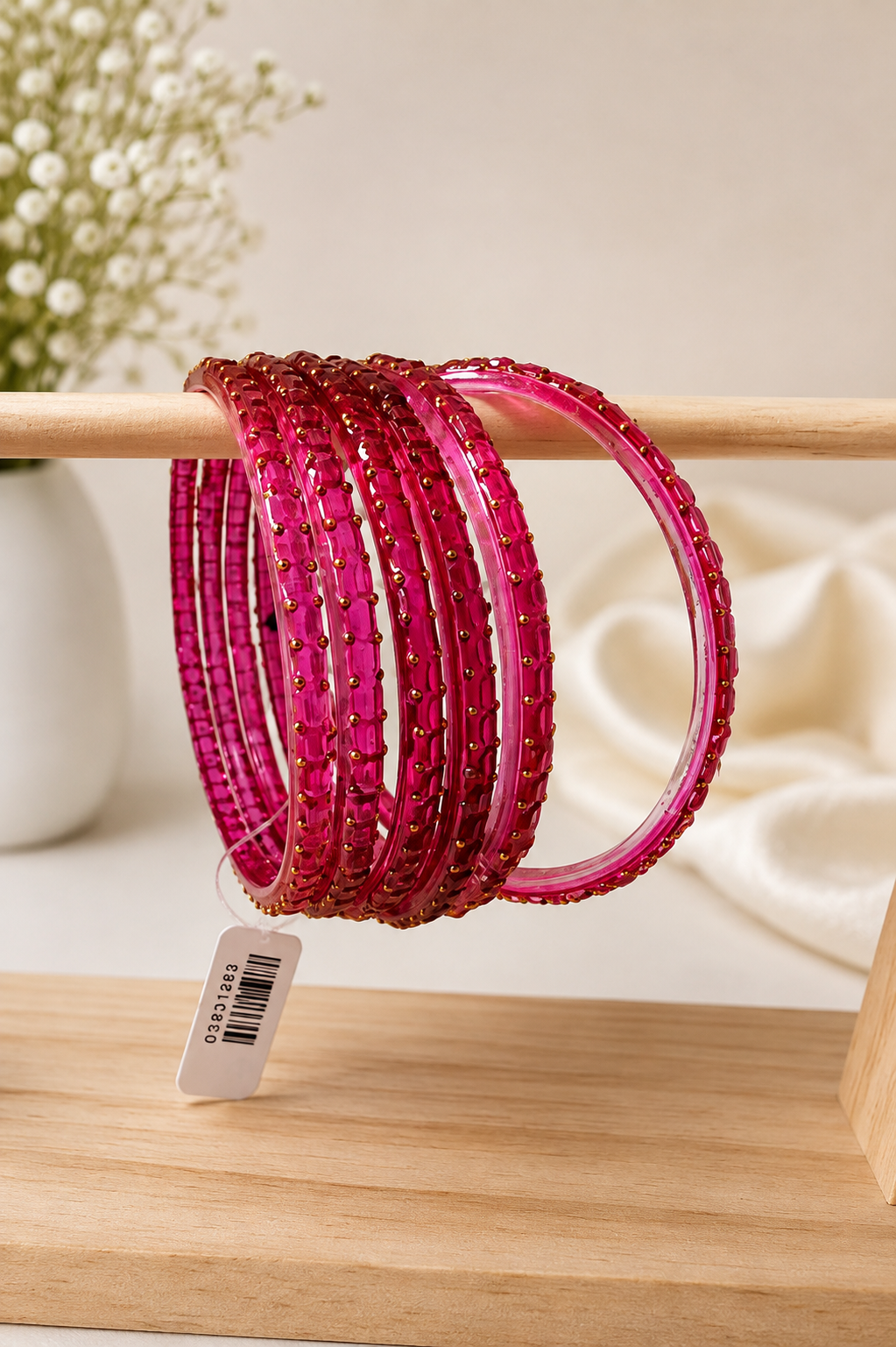 Electric pink Navrang Sparkle Glass Bangles Set by Belumiee showcasing shiny, colorful glass bangles on a display.