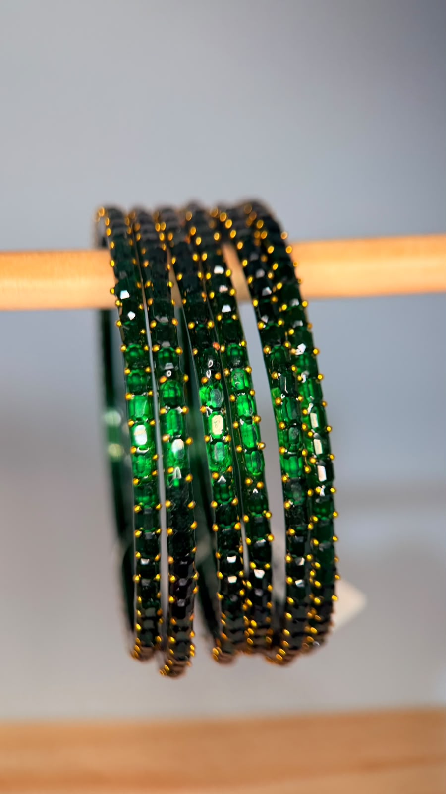 Emerald green Navrang Sparkle Glass Bangles set by Belumiee with shiny, reflective surfaces on a neutral background.