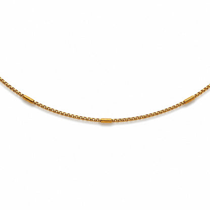 Close-up of gold-tone hip chain with evenly spaced textured barrel accents