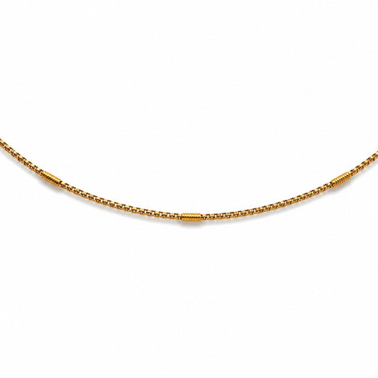 Close-up of gold-tone hip chain with evenly spaced textured barrel accents