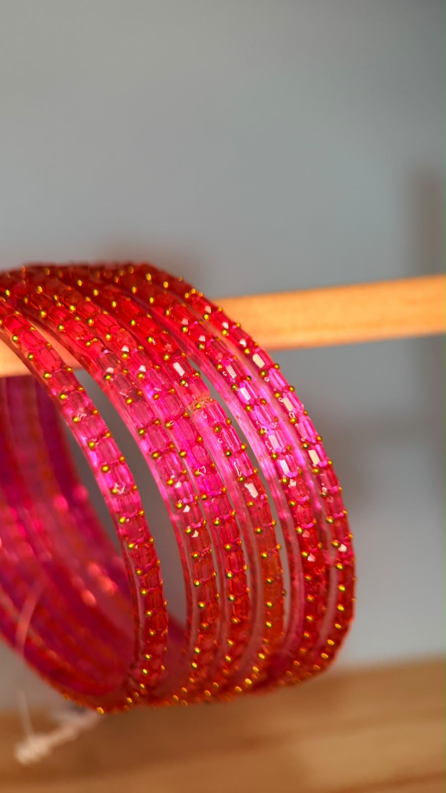 Belumiee Navrang Sparkle Glass Bangles Set featuring light ruby-colored bangles with sparkling glass accents.
