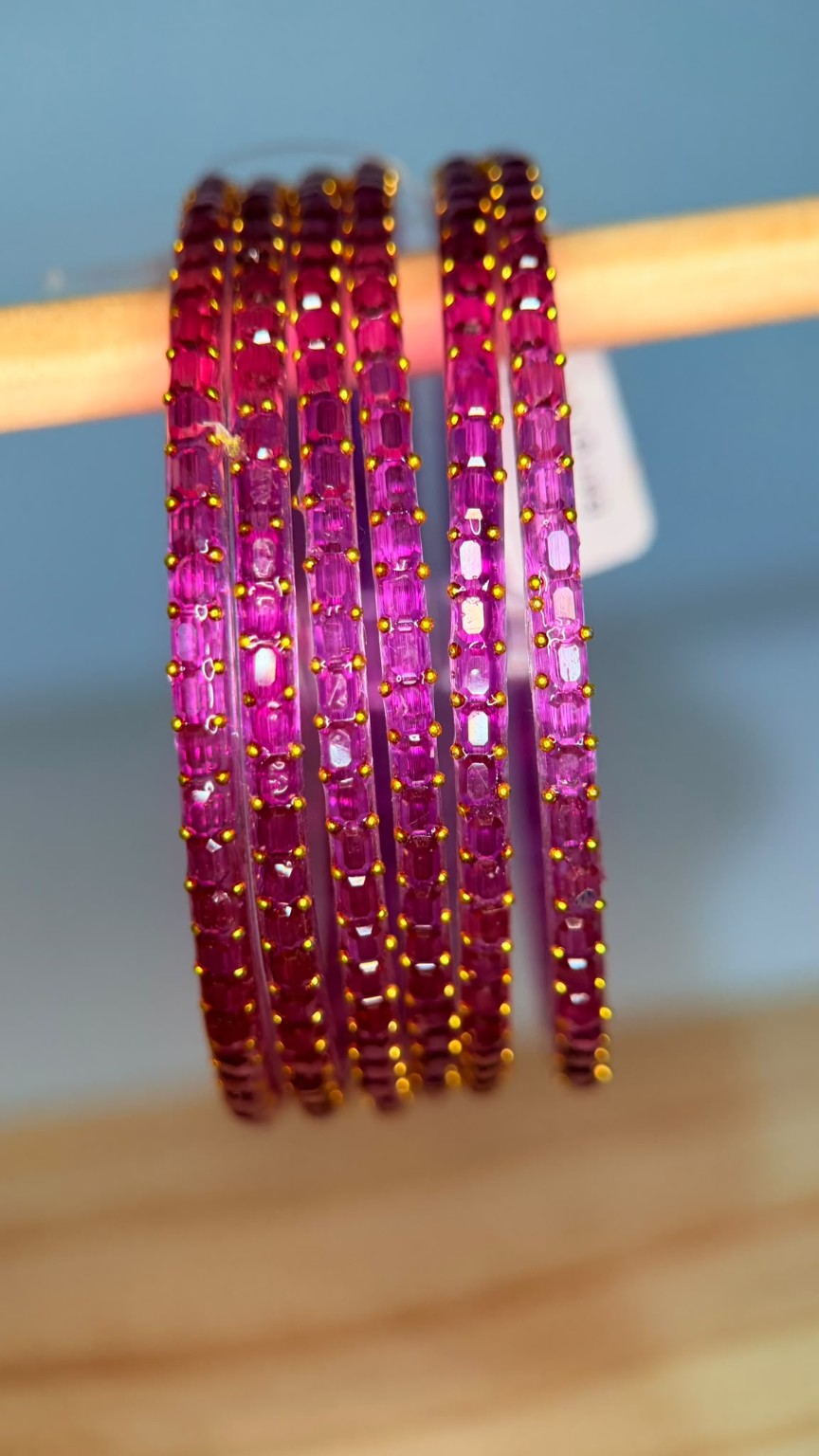 Magenta Navrang Sparkle Glass Bangles Set by Belumiee displayed on a white background, showcasing shiny, decorative bangles.