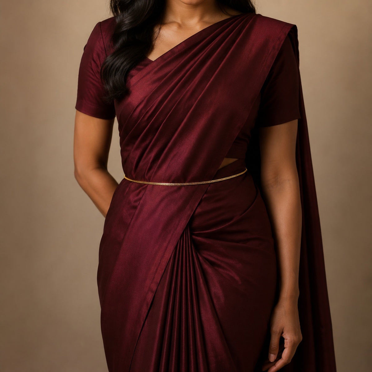 Model wearing minimalist double-row gold-tone hip chain with burgundy saree