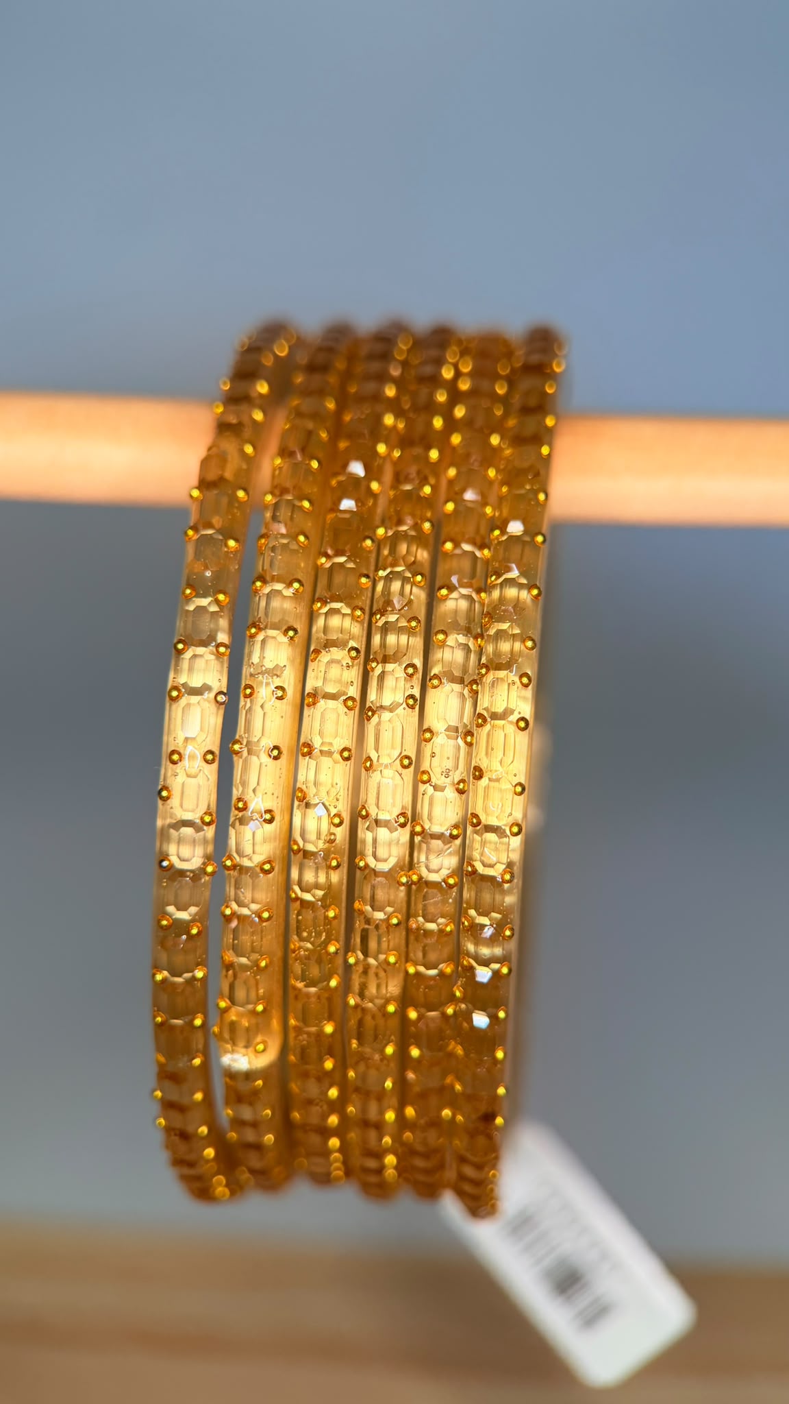 Belumiee Navrang Sparkle glass bangles set with pale gold finish, featuring intricate designs and shimmering accents.