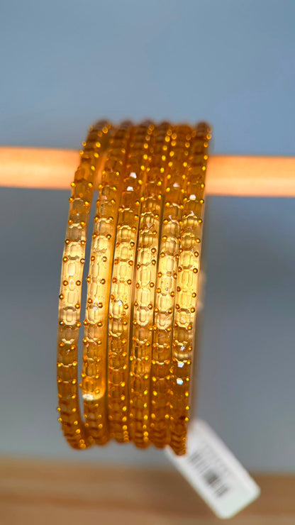 Belumiee Navrang Sparkle glass bangles set with pale gold finish, featuring intricate designs and shimmering accents.