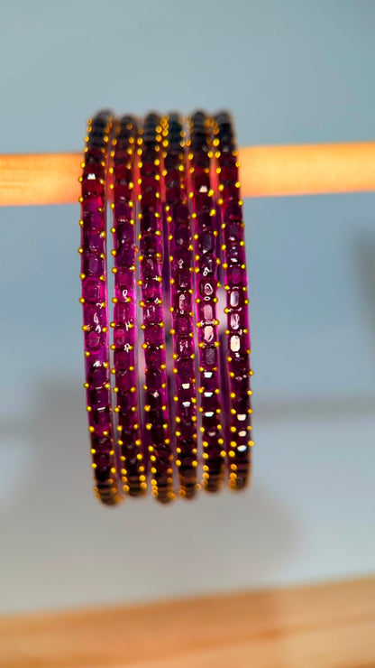 Belumiee Navrang Sparkle Glass Bangles Set with purple and plum-colored bangles featuring glittering designs.
