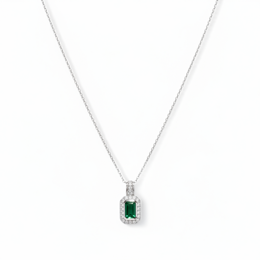 gold necklace with a green gemstone pendant on a white background