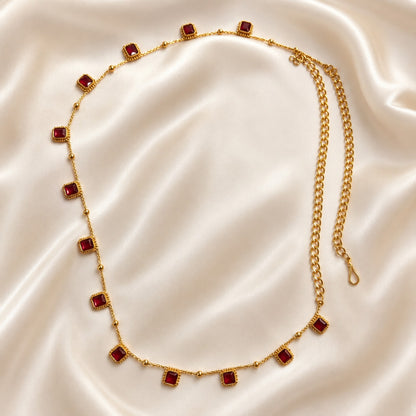 Ruby square stone gold-tone adjustable hip chain laid on ivory satin