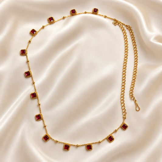 Ruby square stone gold-tone adjustable hip chain laid on ivory satin
