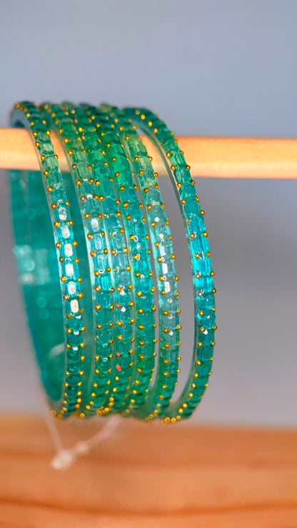 Sea green Navrang Sparkle Glass Bangles Set by Belumiee, showcasing shiny, decorative glass bangles on a neutral background.
